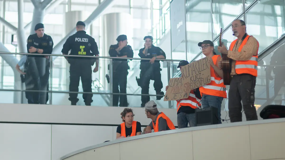 Es gibt sogar Musik - Klimaaktivisten besetzen die Terminals 1 und 3 im Stuttgarter Flughafen. Die Polizei schaut erst einmal zu.