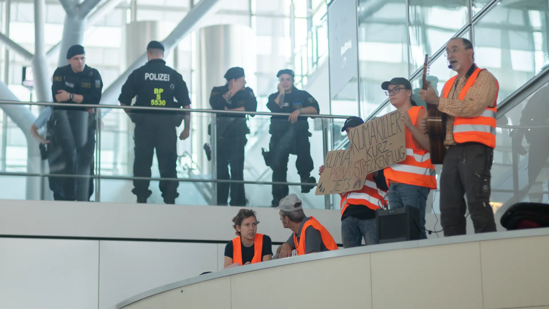 Es gibt sogar Musik - Klimaaktivisten besetzen die Terminals 1 und 3 im Stuttgarter Flughafen. Die Polizei schaut erst einmal zu.