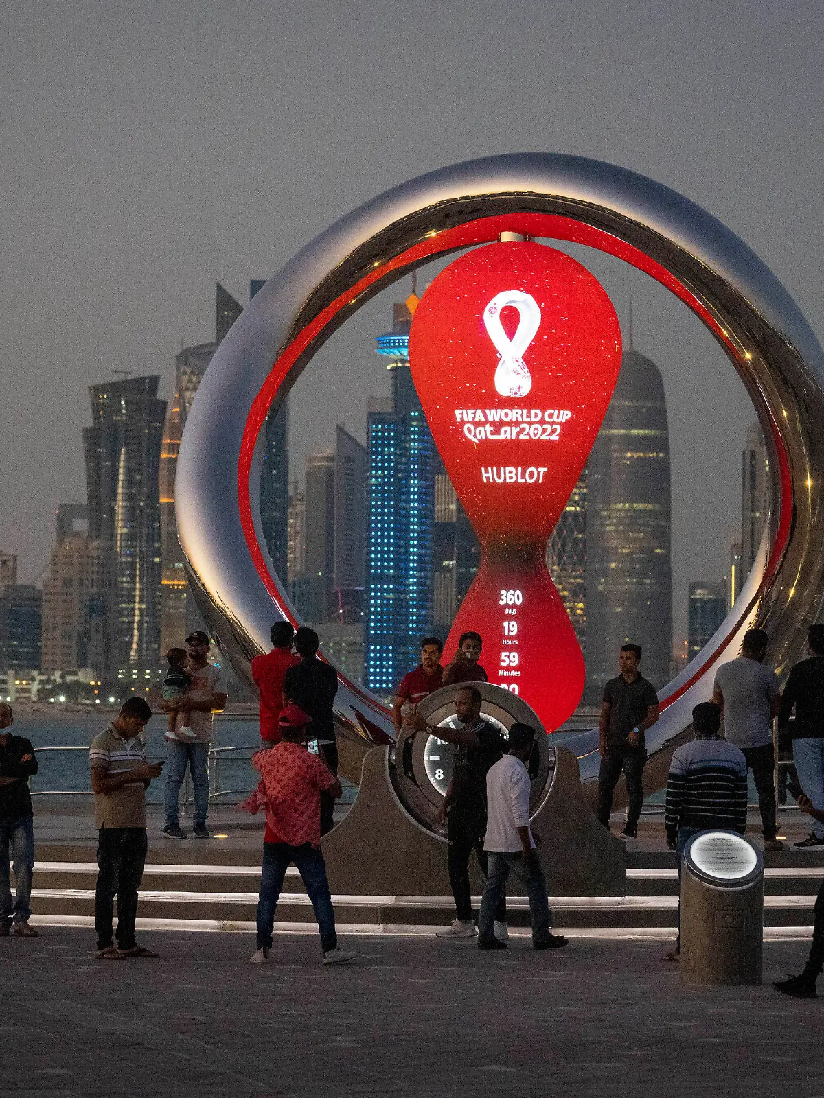 FILE - People gather around the official countdown clock showing remaining time until the kick-off of the World Cup 2022, in Doha, Qatar, Thursday, Nov. 25, 2021. FIFA has received 3 million ticket requests for the World Cup final in Qatar and high demand to attend some of its biggest group-stage games. The data revealed to The Associated Press by FIFA shows there have been 2.5 million ticket requests to see Argentina play Mexico on Nov. 26 at the 80,000-capacity Lusail Stadium and 1.4 million fans hope to see England face the United States the previous day at the 60,000-capacity Al Bayt Stadium. There have been more than two million ticket requests overall from the U.S., England and Qatar. (AP Photo/Darko Bandic, File)
