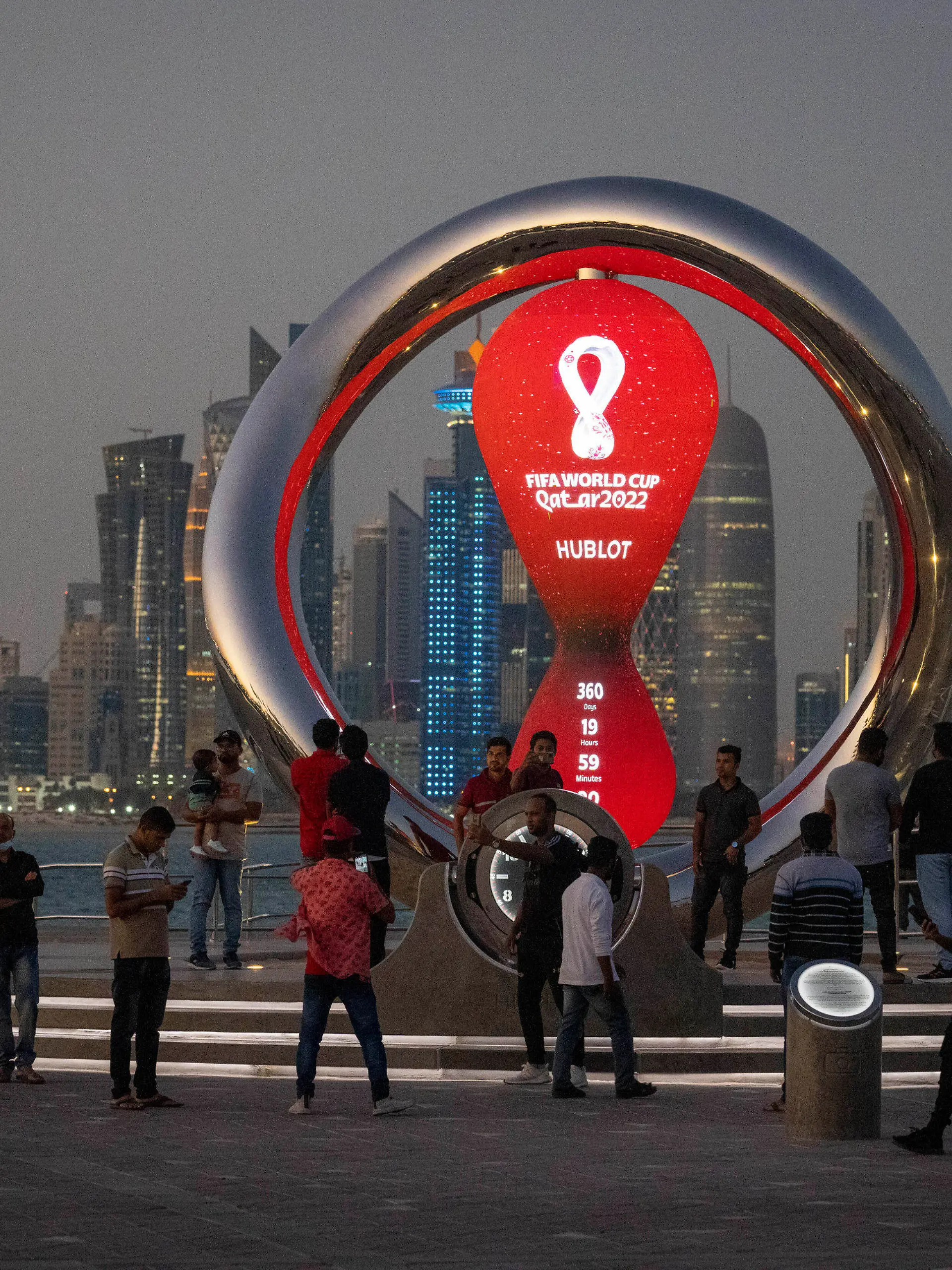 FILE - People gather around the official countdown clock showing remaining time until the kick-off of the World Cup 2022, in Doha, Qatar, Thursday, Nov. 25, 2021. FIFA has received 3 million ticket requests for the World Cup final in Qatar and high demand to attend some of its biggest group-stage games. The data revealed to The Associated Press by FIFA shows there have been 2.5 million ticket requests to see Argentina play Mexico on Nov. 26 at the 80,000-capacity Lusail Stadium and 1.4 million fans hope to see England face the United States the previous day at the 60,000-capacity Al Bayt Stadium. There have been more than two million ticket requests overall from the U.S., England and Qatar. (AP Photo/Darko Bandic, File)
