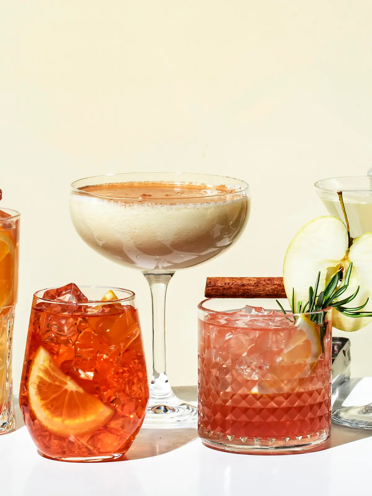 Cocktail party. Bright fruity and citrus alcoholic drinks with gin, vodka, vermouth and juice. Beige background, hard light, shadow pattern. Banner
