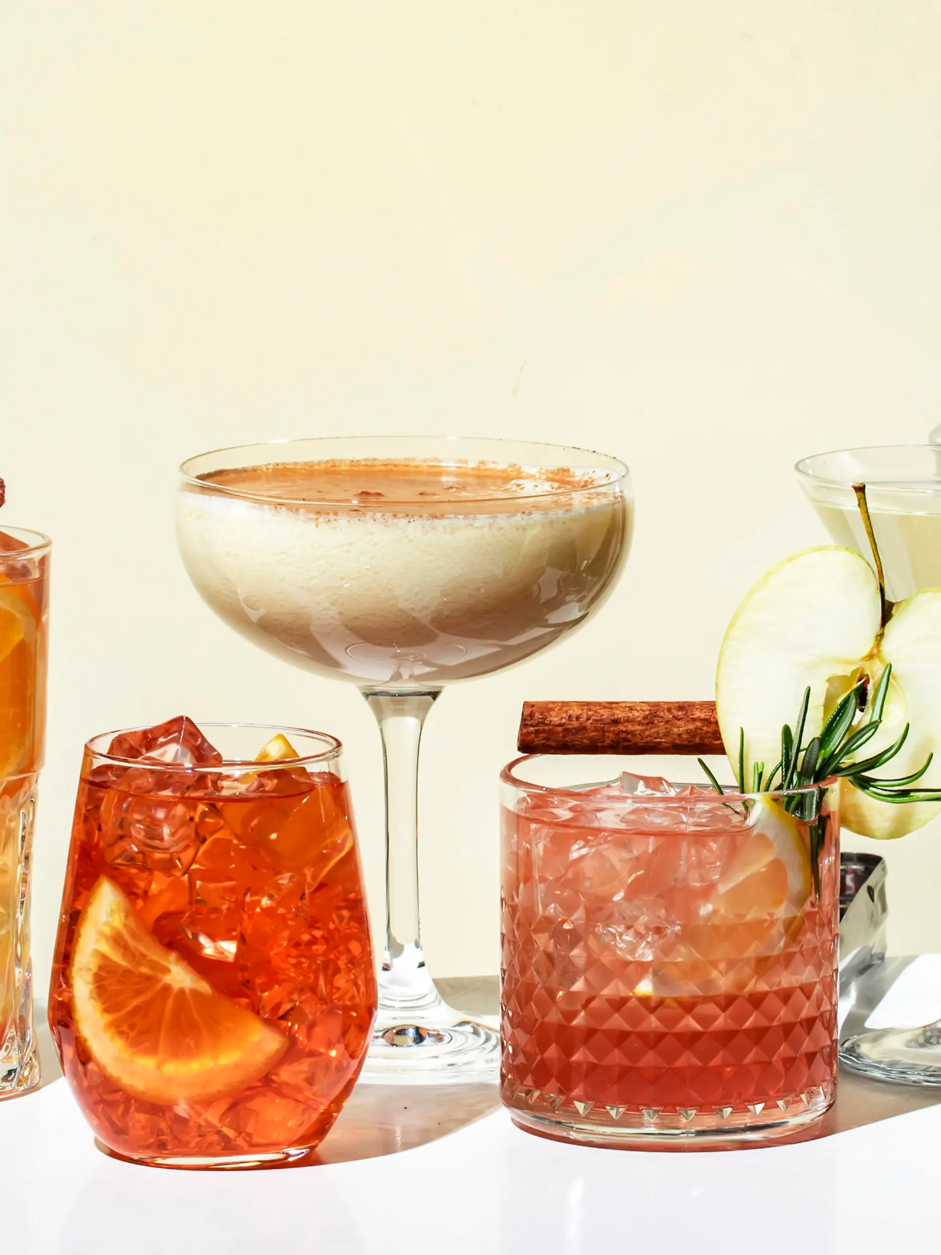 Cocktail party. Bright fruity and citrus alcoholic drinks with gin, vodka, vermouth and juice. Beige background, hard light, shadow pattern. Banner