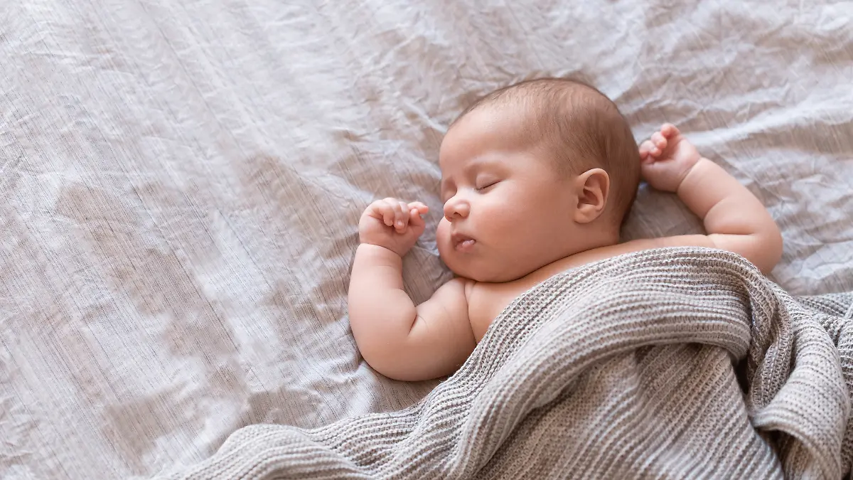 Ein Baby schläft friedlich in seinem Bettchen.
