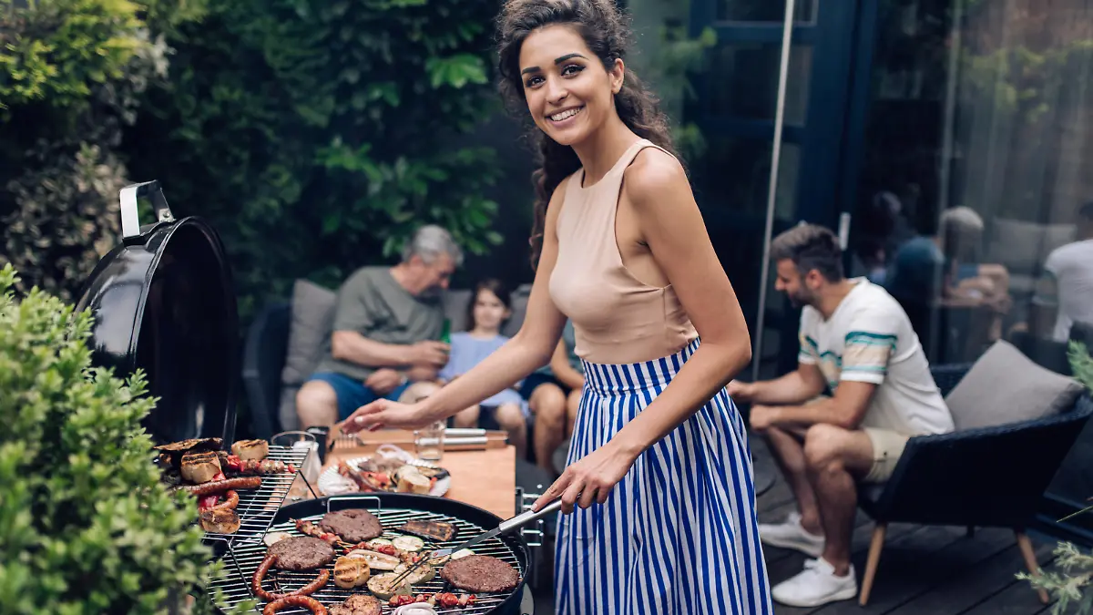 Mid adult woman preparing barbecue for the whole family at the backyard.