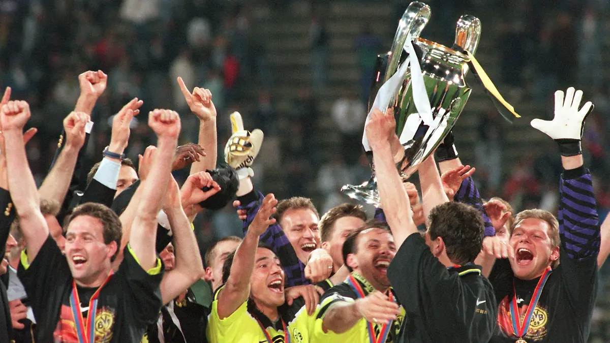 Der Dortmunder Einwechselspieler Michael Zorc reckt am späten Abend des 28.5.1997 im Münchner Olympiastadion triumphierend und unter dem Jubel seiner Mannschaftskameraden den gewonnenen Europapokal in die Höhe. Im Finale der europäischen Fußball-Champions League schlägt Borussia Dortmund den italienischen Meister Juventus Turin mit 3:1 und macht in seinem 100. Europapokalspiel den größten Triumph in seiner Vereinsgeschichte perfekt. [dpabilderarchiv]