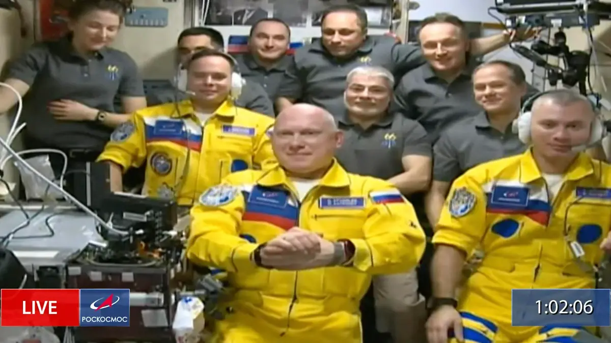 SCREENSHOT - 19.03.2022, ---: HANDOUT - In diesem von Roskosmos zur Verfügung gestellten Videostandbild sind die russischen Kosmonauten Sergej Korsakow (l-r), Oleg Artemjew und Denis Matwejew während einer Begrüßungszeremonie nach ihrer Ankunft an der Internationalen Raumstation (ISS) zu sehen. Inmitten schwerster Spannungen zwischen Russland und dem Westen ist eine rein russische Besatzung an der Internationalen Raumstation ISS mit Umarmungen und Klatschen in Empfang genommen worden. Die drei Kosmonauten trugen gelbe Anzüge mit einigen blauen Aufnähern. Beobachter erinnerte das an die Farben der ukrainischen Flagge. Ob damit eine Botschaft verbunden war, war zunächst unklar. Foto: Uncredited/Roscosmos/AP/dpa +++ dpa-Bildfunk +++