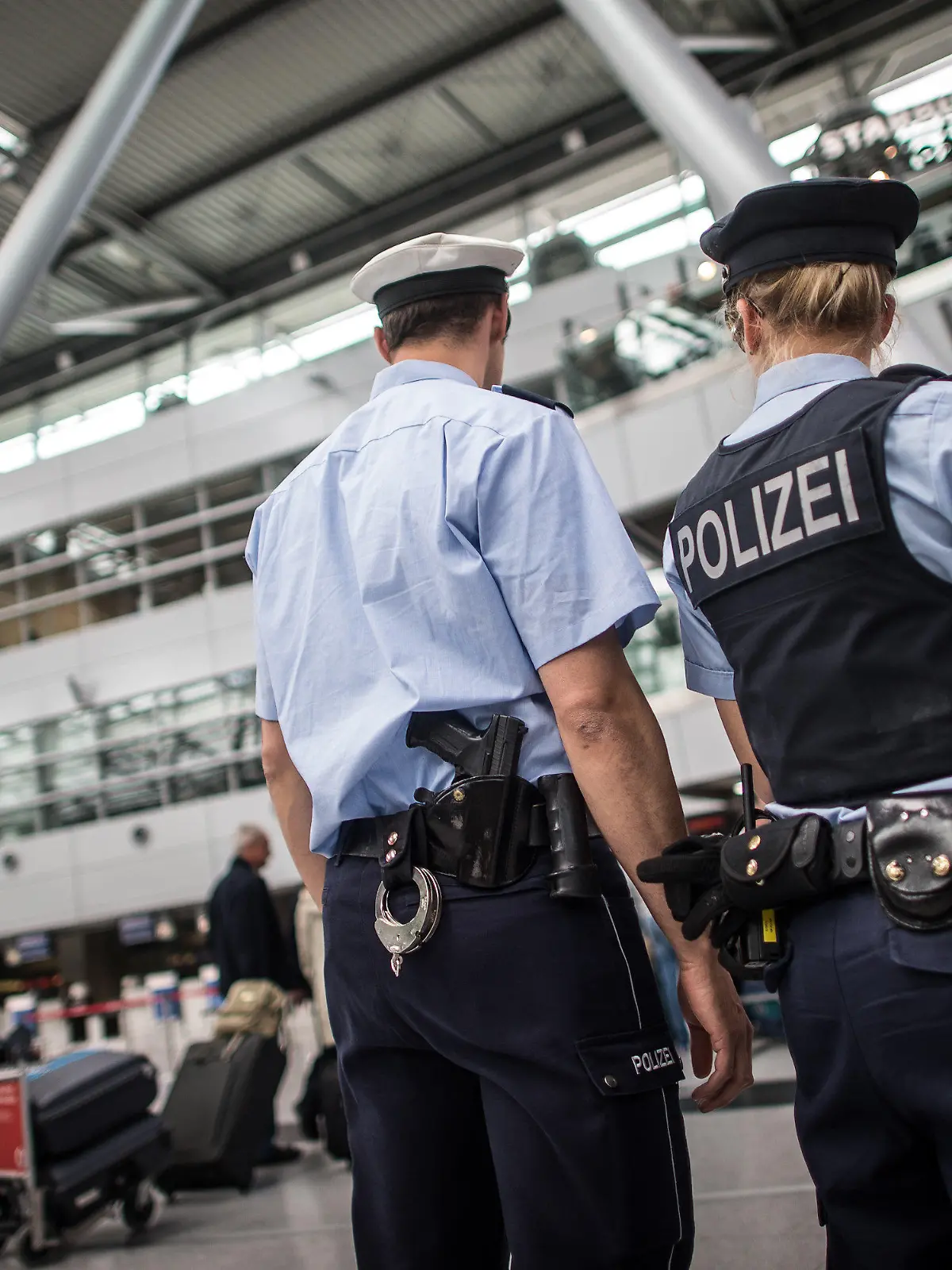Polizei- und Sicherheitsbeamte stehen am 19.05.2015 am Flughafen in Düsseldorf (Nordrhein-Westfalen) bei einem Pressetermin zur Bekämpfung der Diebstahlkriminalität am Flughafen in der Abflughalle. Foto: Maja Hitij/dpa +++(c) dpa - Bildfunk+++