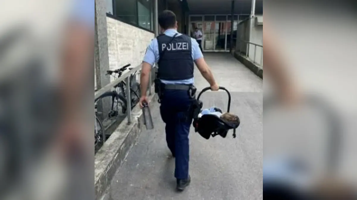 Ein Bundespolizist trägt das Mädchen am Hauptbahnhof München.