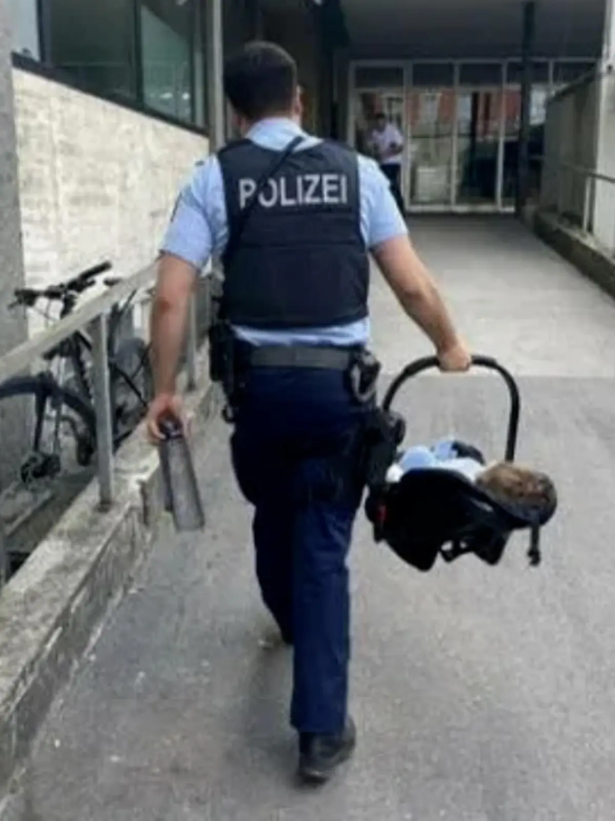 Ein Bundespolizist trägt das Mädchen am Hauptbahnhof München.