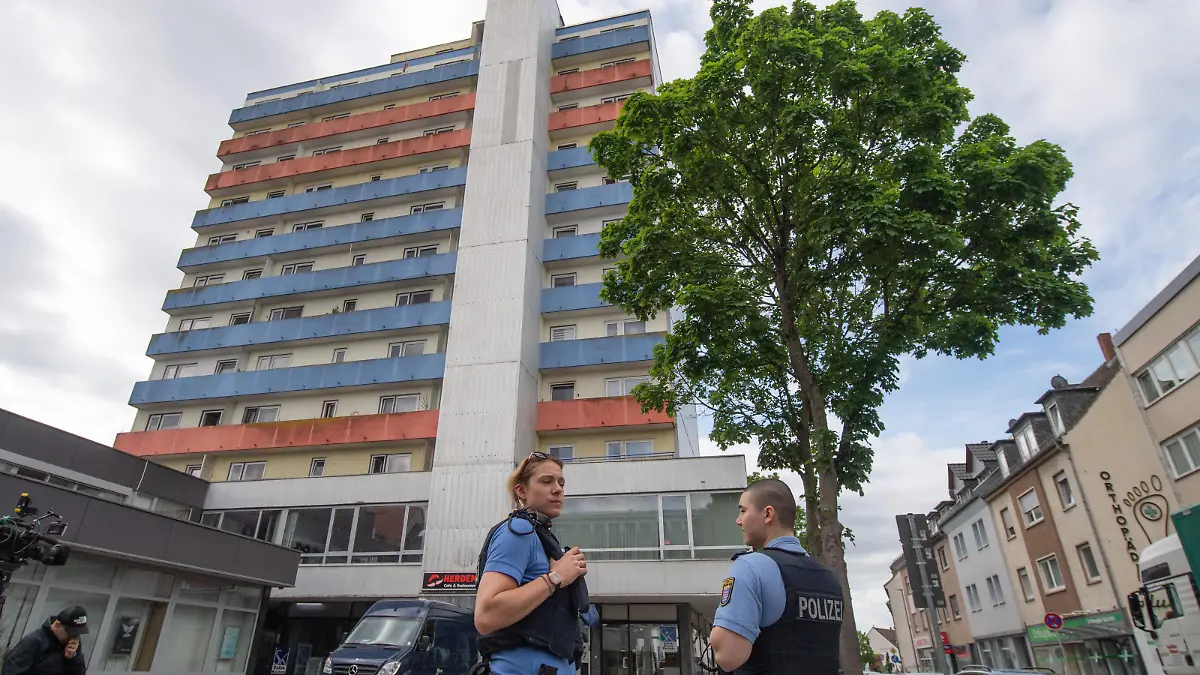 12.05.2022, Hessen, Hanau: Polizisten stehen vor einem Hochhaus, in dem am Vortag zwei Kinder zu Tode gekommen waren. Während die genauen Hintergründe der Tat noch unklar sind, geht die Polizei von einem familiären Hintergrund aus und fahndet nach einem Tatverdächtigen. Foto: Boris Roessler/dpa +++ dpa-Bildfunk +++