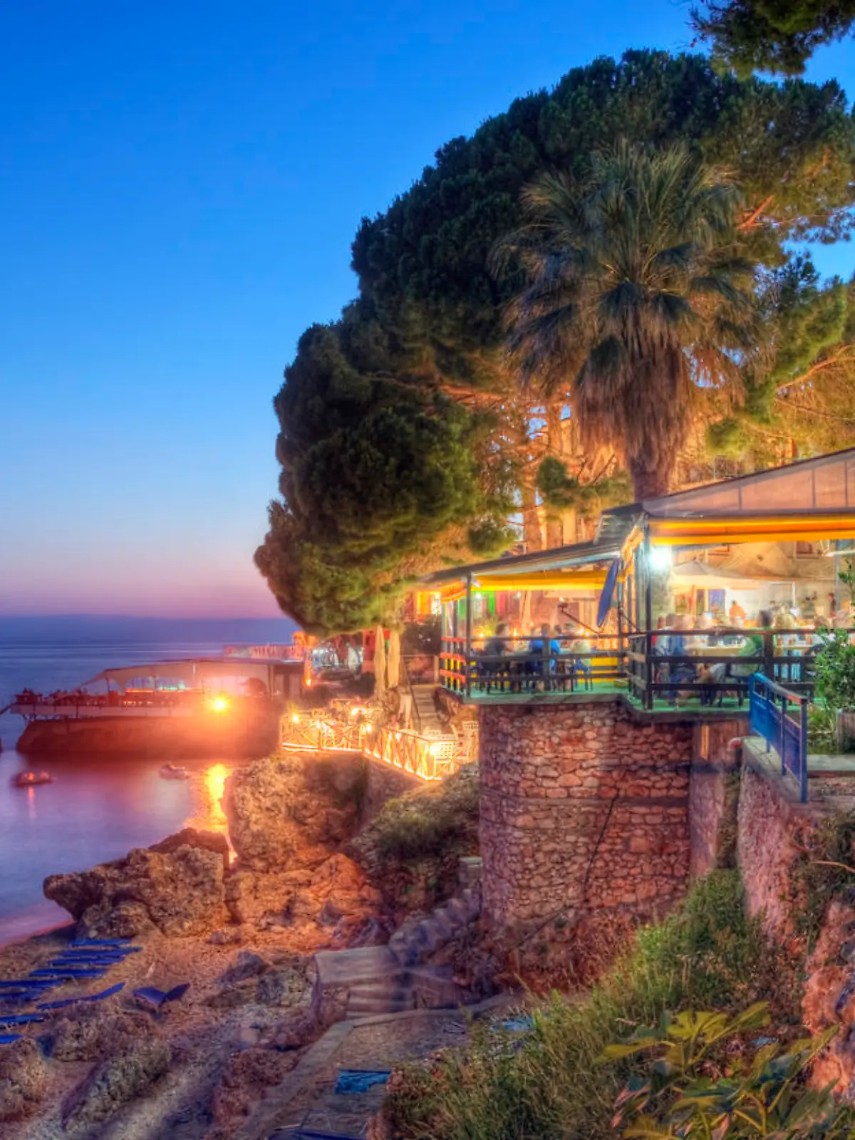 Restaurants and hotels by the beach in the village of Dhermia, located in the Albanian Riveria on the Ionian coast.

This scene by day:
[url=file_closeup.php?id=16224995][img]file_thumbview_approve.php?size=1&id=16224995[/img][/url]

Please see my related collections...

[url=search/lightbox/7431206][img]http://i161.photobucket.com/albums/t218/dave9296/Lightbox_Vetta.jpg[/img][/url]

[url=search/lightbox/6710118][img]http://i161.photobucket.com/albums/t218/dave9296/Lightbox_Albania-V2.jpg[/img][/url]
[url=search/lightbox/4714279][img]http://i161.photobucket.com/albums/t218/dave9296/Lightbox_mediterranean1-V2.jpg[/img][/url]
[url=search/lightbox/9764345][img]http://i161.photobucket.com/albums/t218/dave9296/Lightbox_SunriseSunset.jpg[/img][/url] 
[url=search/lightbox/8833461][img]http://i161.photobucket.com/albums/t218/dave9296/Lightbox_Balkans.jpg[/img][/url]
[url=search/lightbox/4719824][img]http://i161.photobucket.com/albums/t218/dave9296/Lightbox_travelers-V2.jpg[/img][/url]
[url=search/lightbox/6315481][img]http://i161.photobucket.com/albums/t218/dave9296/Lightbox_HDR2-V2.jpg[/img][/url]