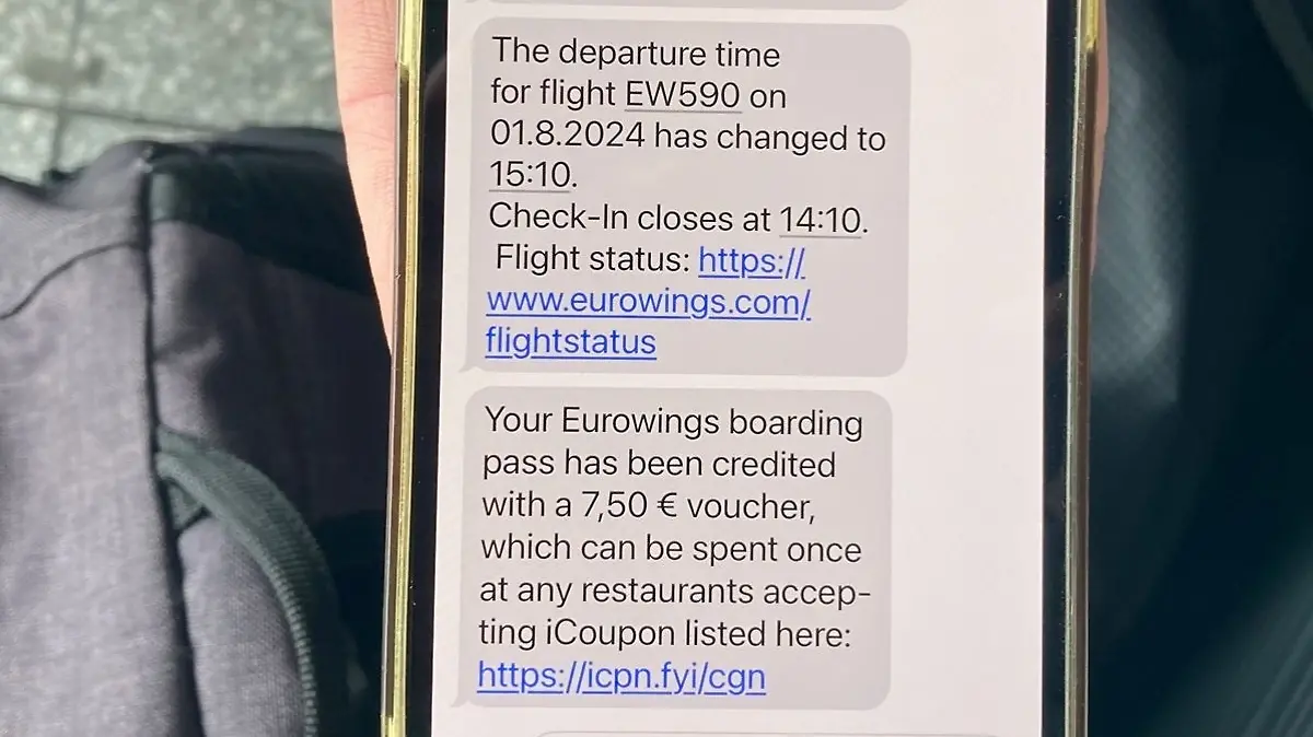 Der Text auf dem Handy einer Reisenden zeigt, dass Eurowings 7,50 Euro für Verpflegung zur Verfügung stellt.