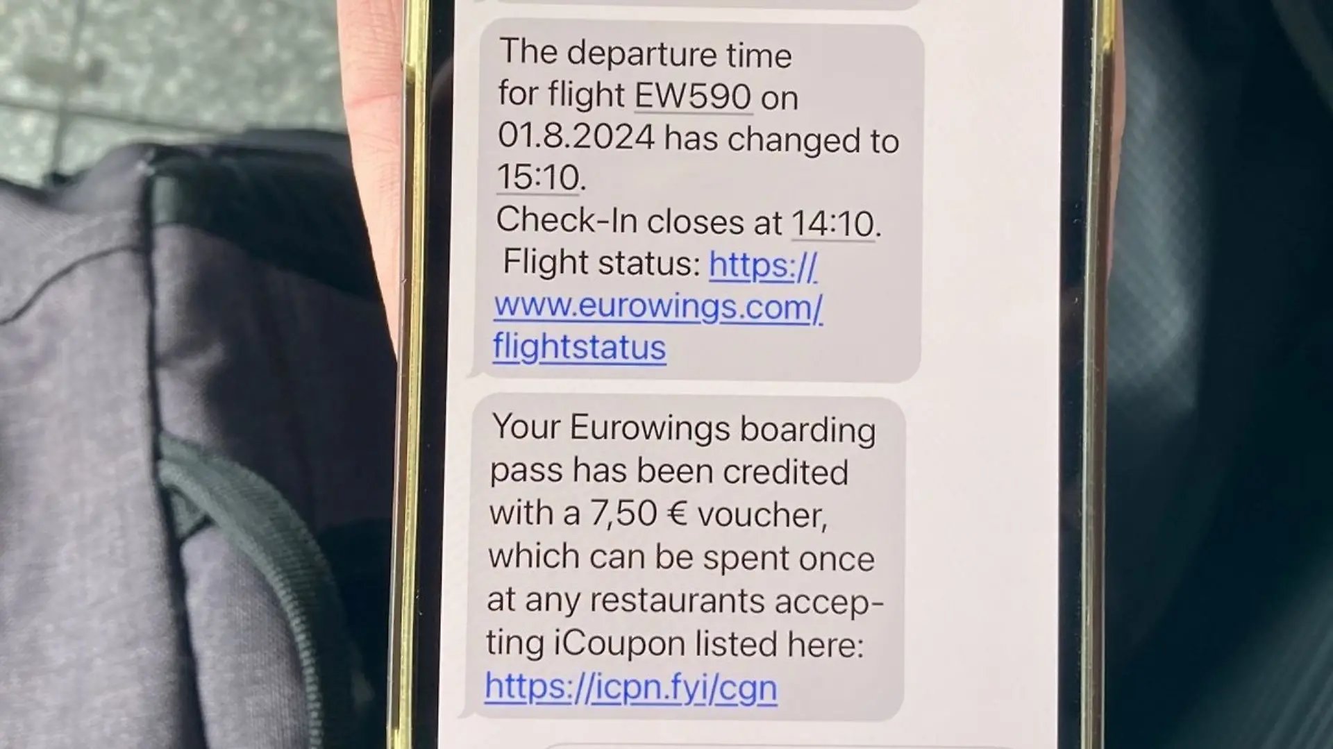 Der Text auf dem Handy einer Reisenden zeigt, dass Eurowings 7,50 Euro für Verpflegung zur Verfügung stellt.