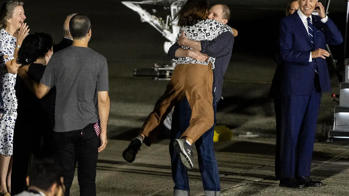 Evan Gershkovich, the Wall Street Journal reporter held captive by the Russian government, lifts his mother, Ella Milman, in the air as he arrives in the United States at Joint Base Andrews on August 1, 2024 in Maryland. Gershkovich is part of a 24-person prisoner swap between Russia, the United States, Germany and three other western countries. (Photo by Samuel Corum/Sipa USA)