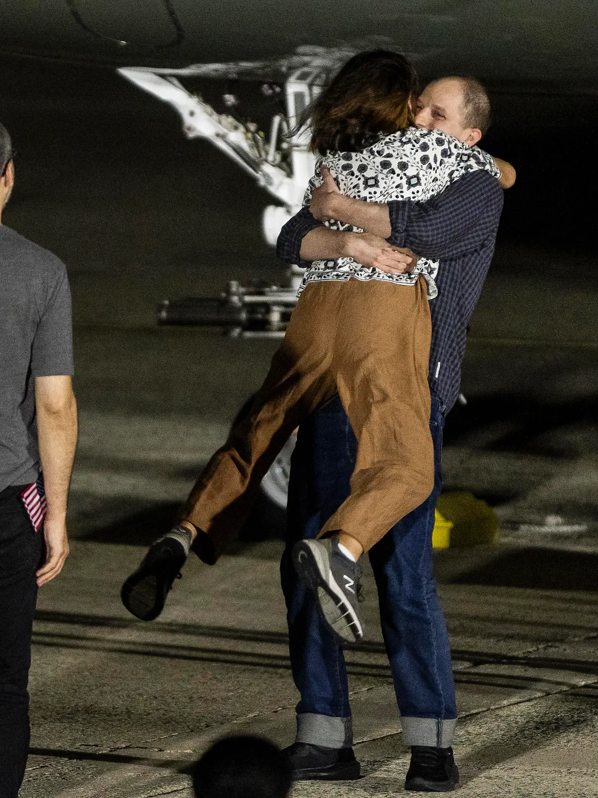 Evan Gershkovich, the Wall Street Journal reporter held captive by the Russian government, lifts his mother, Ella Milman, in the air as he arrives in the United States at Joint Base Andrews on August 1, 2024 in Maryland. Gershkovich is part of a 24-person prisoner swap between Russia, the United States, Germany and three other western countries. (Photo by Samuel Corum/Sipa USA)