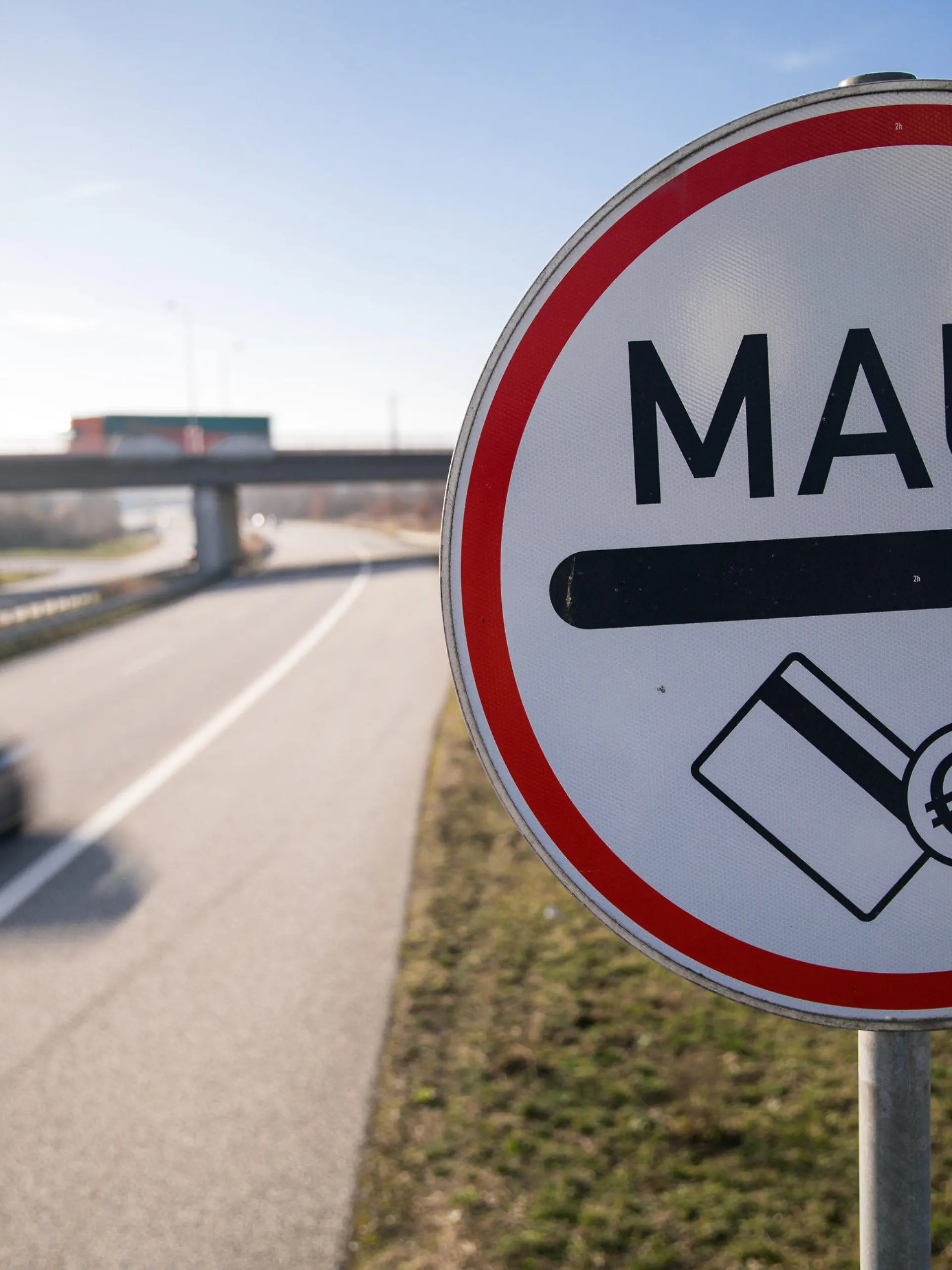 ARCHIV - 25.02.2019, Mecklenburg-Vorpommern, Rostock: Ein Verkehrsschild weist die Autofahrer der Stadtautobahn auf die Mautpflicht für die Passage des Warnowtunnels hin. Im Streit um Schadenersatz für die geplatzte Pkw-Maut gibt es nach Angaben der Betreiberseite eine Verständigung. Wie das Unternehmen Kapsch am Mittwoch in einer Börsen-Pflichtmitteilung mitteilte, ist «aufgrund einer erzielten vergleichsweisen Einigung mit der Bundesrepublik Deutschland» eine Zahlung des Bundes von 243 Millionen Euro zu erwarten. Zunächst berichtete der «Spiegel» darüber. Foto: Jens Büttner/zb/dpa +++ dpa-Bildfunk +++