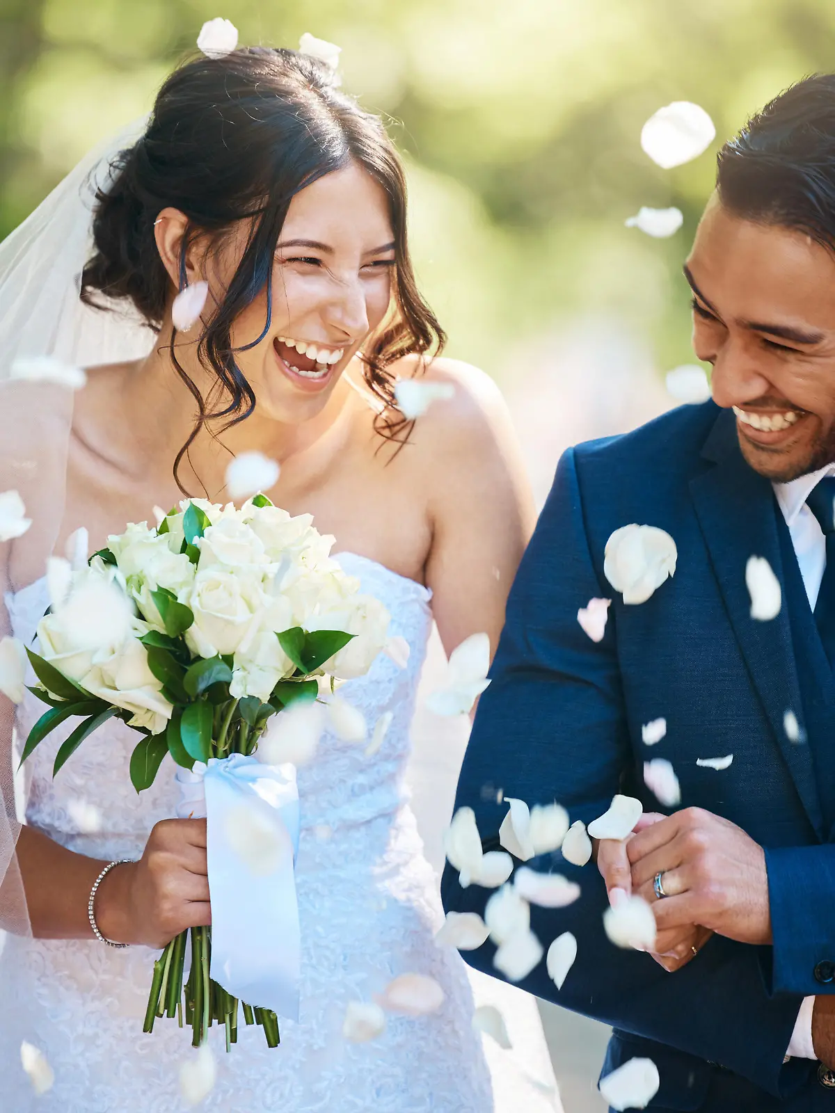 Guests throwing confetti over bride and groom as they walk past after their wedding ceremony. Joyful young couple celebrating their wedding day