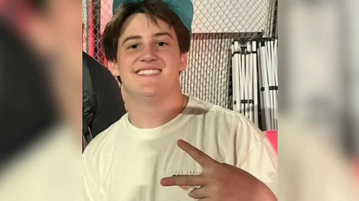 Ein Teenager mit einer grünen Cappe auf dem Kopf.
