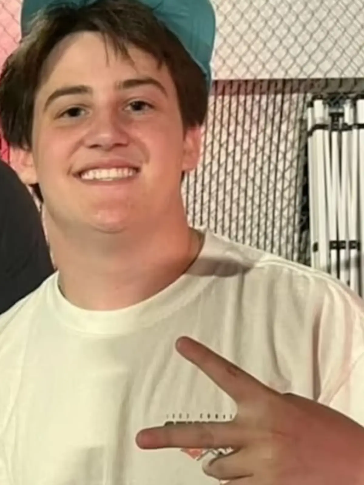 Ein Teenager mit einer grünen Cappe auf dem Kopf.