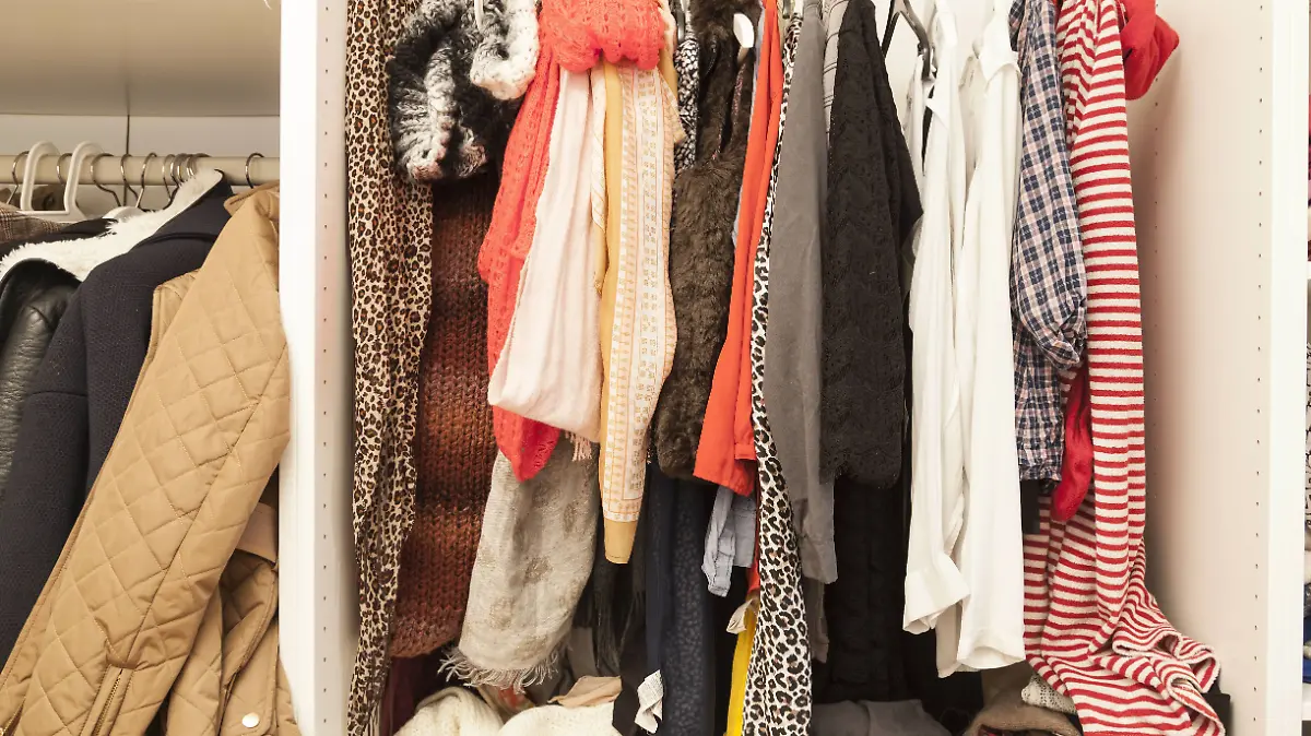 Ein offener Kleiderschrank mit vielen Kleidungsstücken.