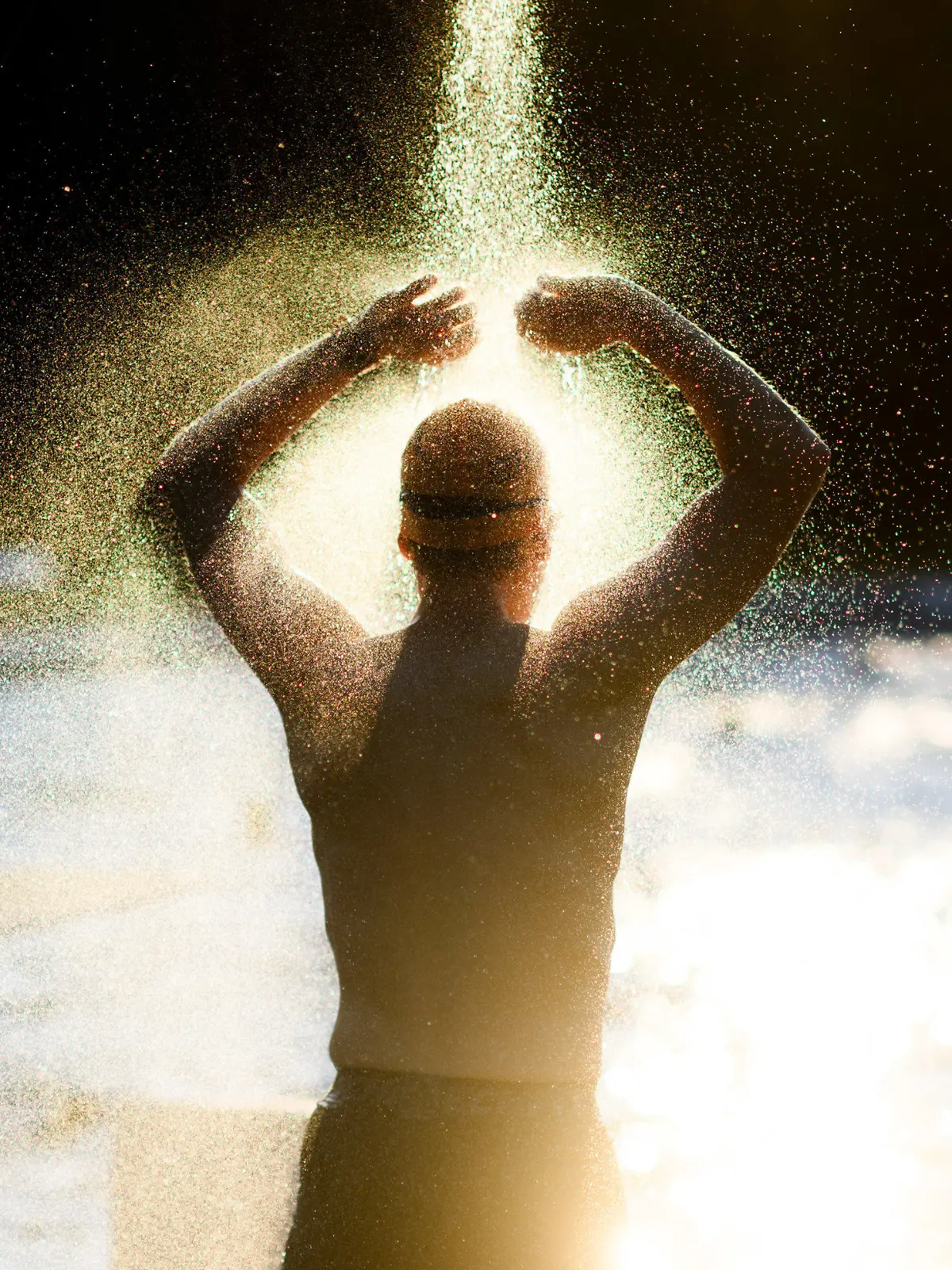 30.07.2024, Niedersachsen, Hannover: Ein Frühschwimmer duscht am frühen Morgen im Freibad Kleefelder Bad - Annabad im Licht der aufgehenden Sonne. Foto: Julian Stratenschulte/dpa +++ dpa-Bildfunk +++