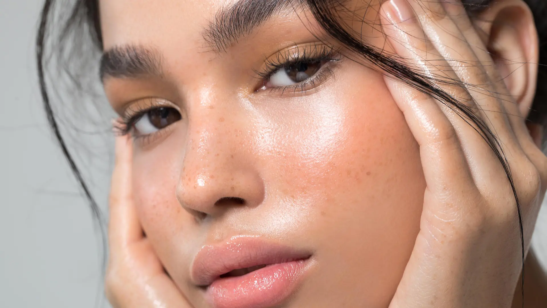 Close up studio shot of a beautiful young woman with perfect glow skin.