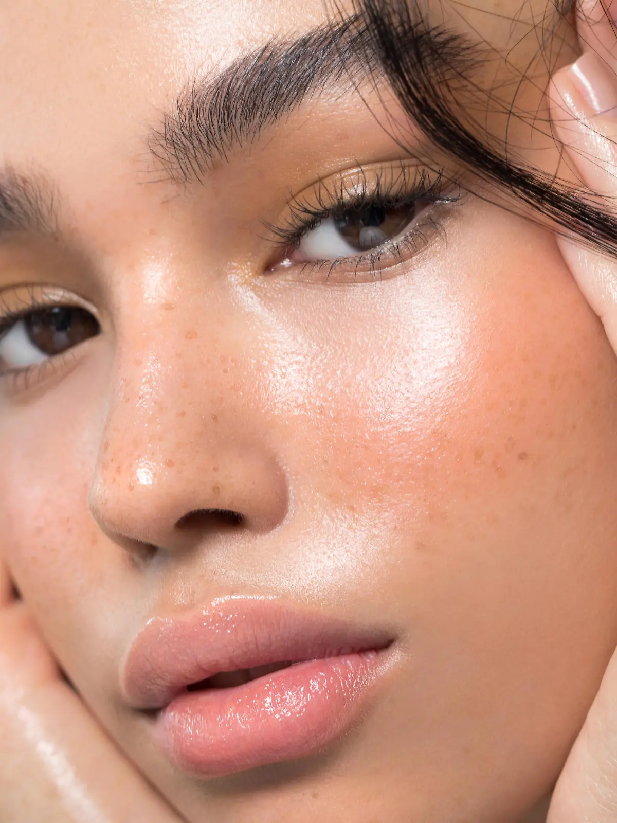 Close up studio shot of a beautiful young woman with perfect glow skin.