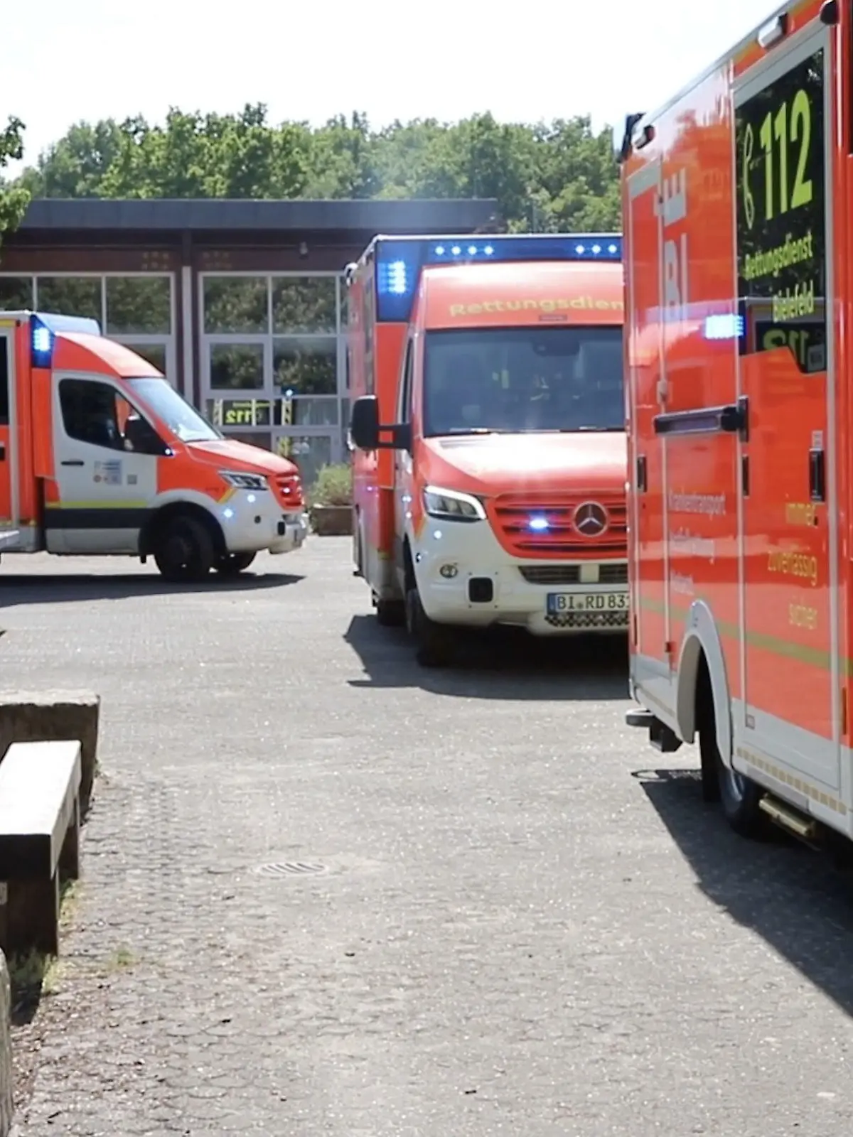 11.05.2022, Nordrhein-Westfalen, Bielefeld: Einsatzfahrzeuge vom Rettungsdienst Bielefeld stehen vor der Schule. Ein Jugendlicher soll in einer Bielefelder Gesamtschule Pfefferspray versprüht und damit Schüler leicht verletzt haben. Diese hätten über Beschwerden geklagt und seien vor Ort untersucht worden, teilten die Behörden am Mittwoch mit. Vier von ihnen seien vorsichtshalber ins Krankenhaus gebracht worden. Foto: Nord-West-Media TV/NWM/dpa +++ dpa-Bildfunk +++