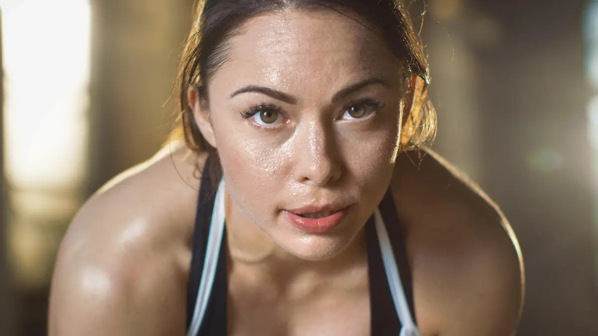 Shot of a Beautiful Athletic Brunette Resting on the Bench and Smiling into the Camera.