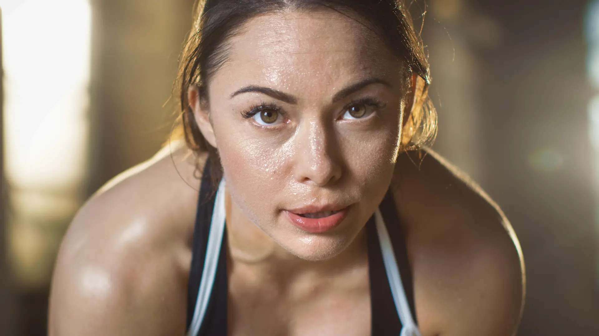 Shot of a Beautiful Athletic Brunette Resting on the Bench and Smiling into the Camera.