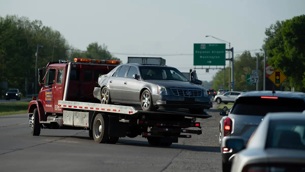 Hamrick's Towing & Recovery hauls the Cadillac sedan that fugitives Casey White and Vicky White, no relation, were driving when law enforcement officials forced them into a ditch at Burch Drive in Evansville, Ind., after a short chase Monday, May 9, 2022. The two have been on the run since Vicky White, a detention officer, helped inmate Casey White escape the Lauderdale County Detention Center on April 28. (Denny Simmons/Evansville Courier & Press via AP)