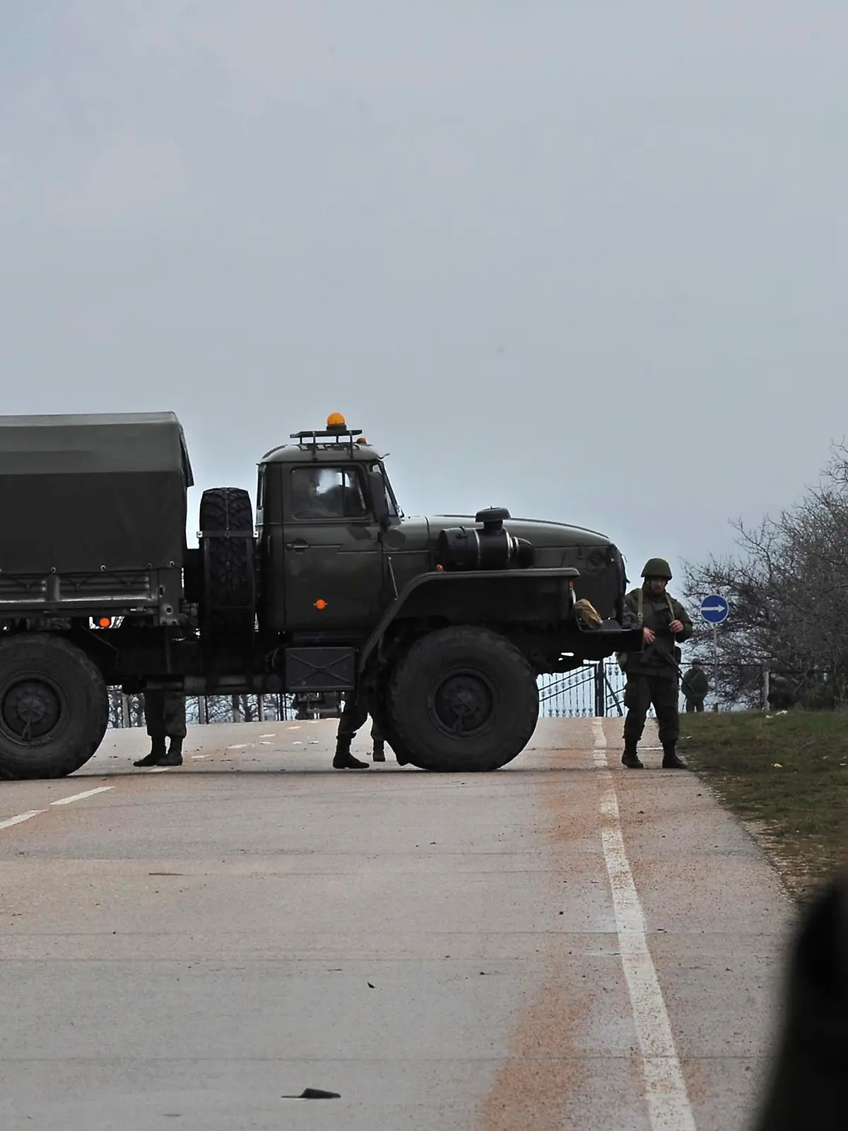 Russian troops block the road way towards the military airport at the Black Sea port of Sevastopol in Crimea, Ukraine, Friday, Feb. 28, 2014. Heightened security is evident with Russian military around Sevastopol, the location for Russia military bases, military airport and Naval Base, while unidentified armed men wearing uniforms without insignia were patrolling another airport serving the regional capital, Ukraine's new Interior Minister Arsen Avakov said on Friday.(AP Photo/Andrew Lubimov)