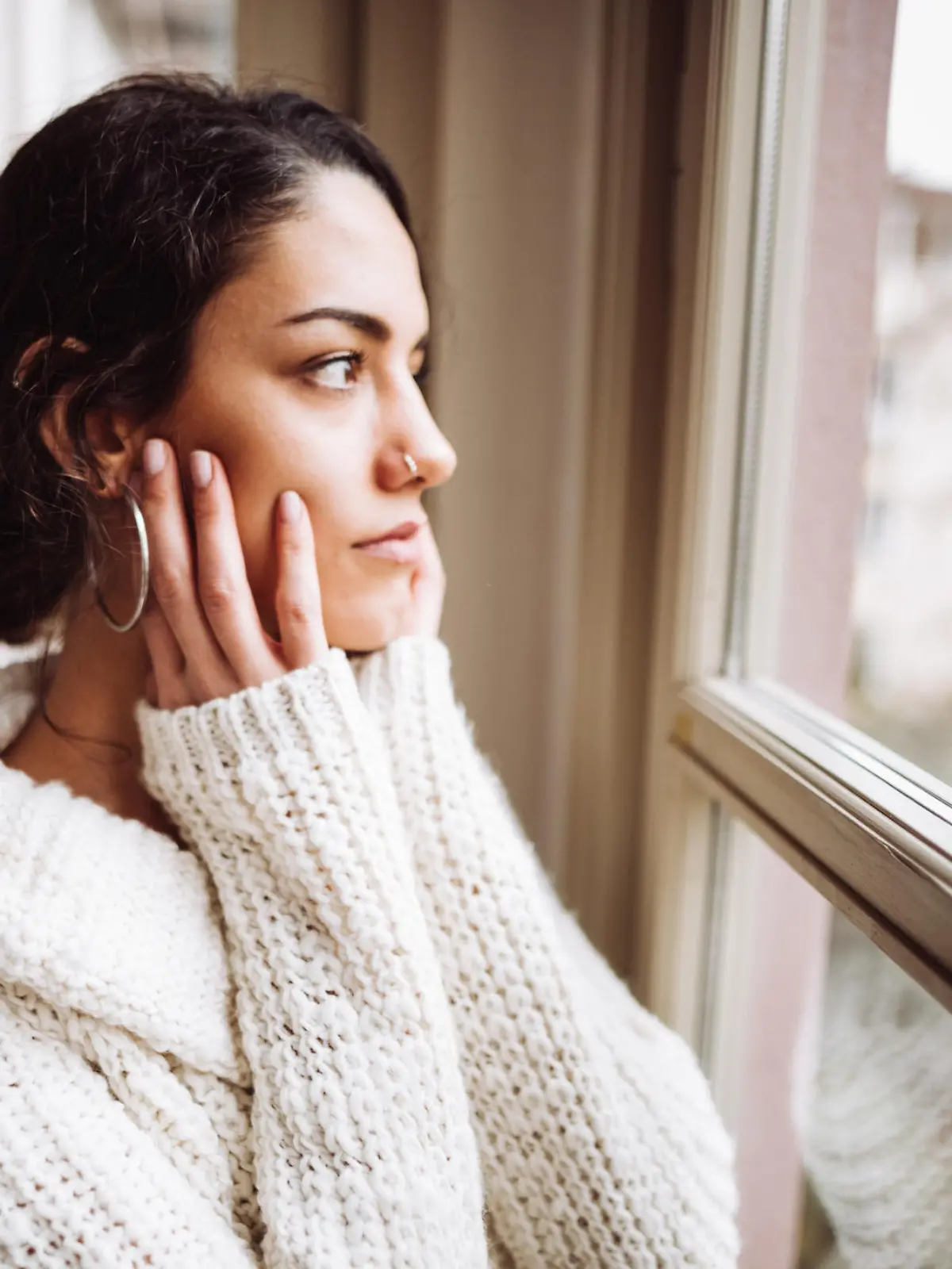 pensive woman in front of the window