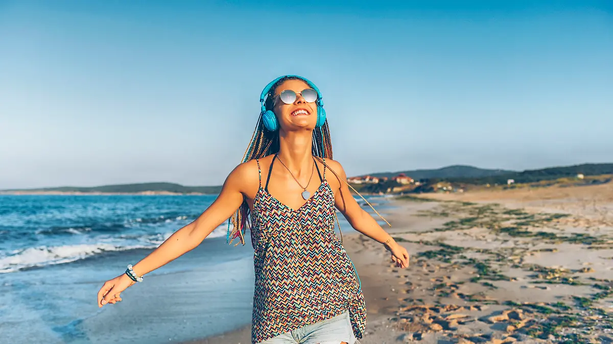 Frau hört Musik am Strand