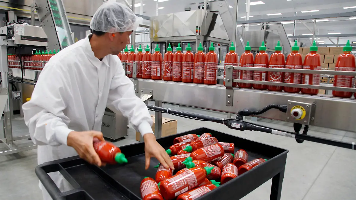 FILE - In this Oct 29, 2013 photo, Sriracha chili sauce is produced at the Huy Fong Foods factory in Irwindale, Calif. Bottles of the popular Sriracha hot sauce could be hard to find on store shelves this summer. Southern California-based Huy Fong Inc., told customers in an email earlier this year that it would suspend sales of its famous spicy sauce over the summer due to a shortage of chili peppers. (AP Photo/Nick Ut, File)