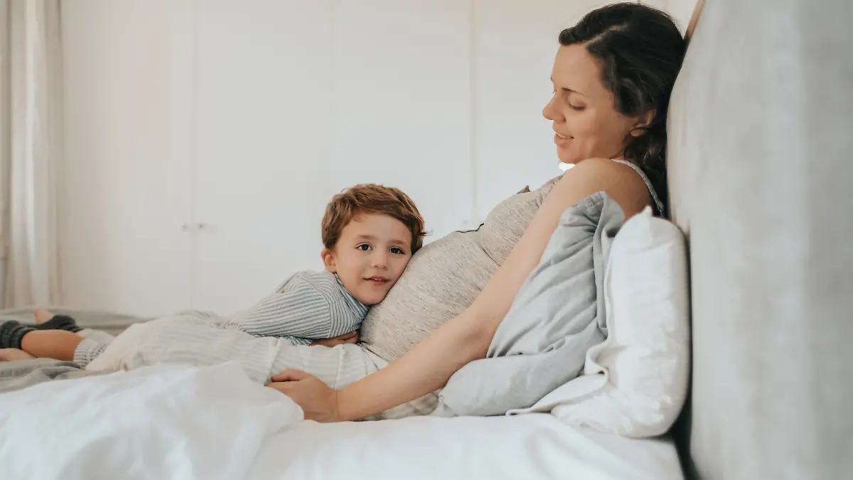 Schwangere und Kind im Bett