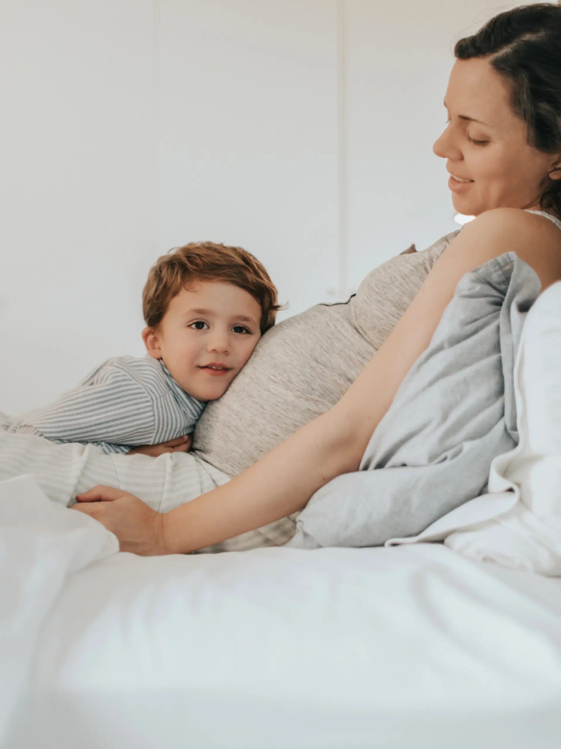 Schwangere und Kind im Bett