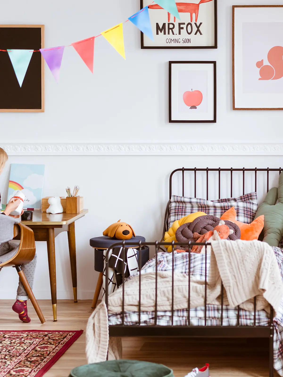 Cute little girl sitting at desk in her stylish vintage bedroom with workspace