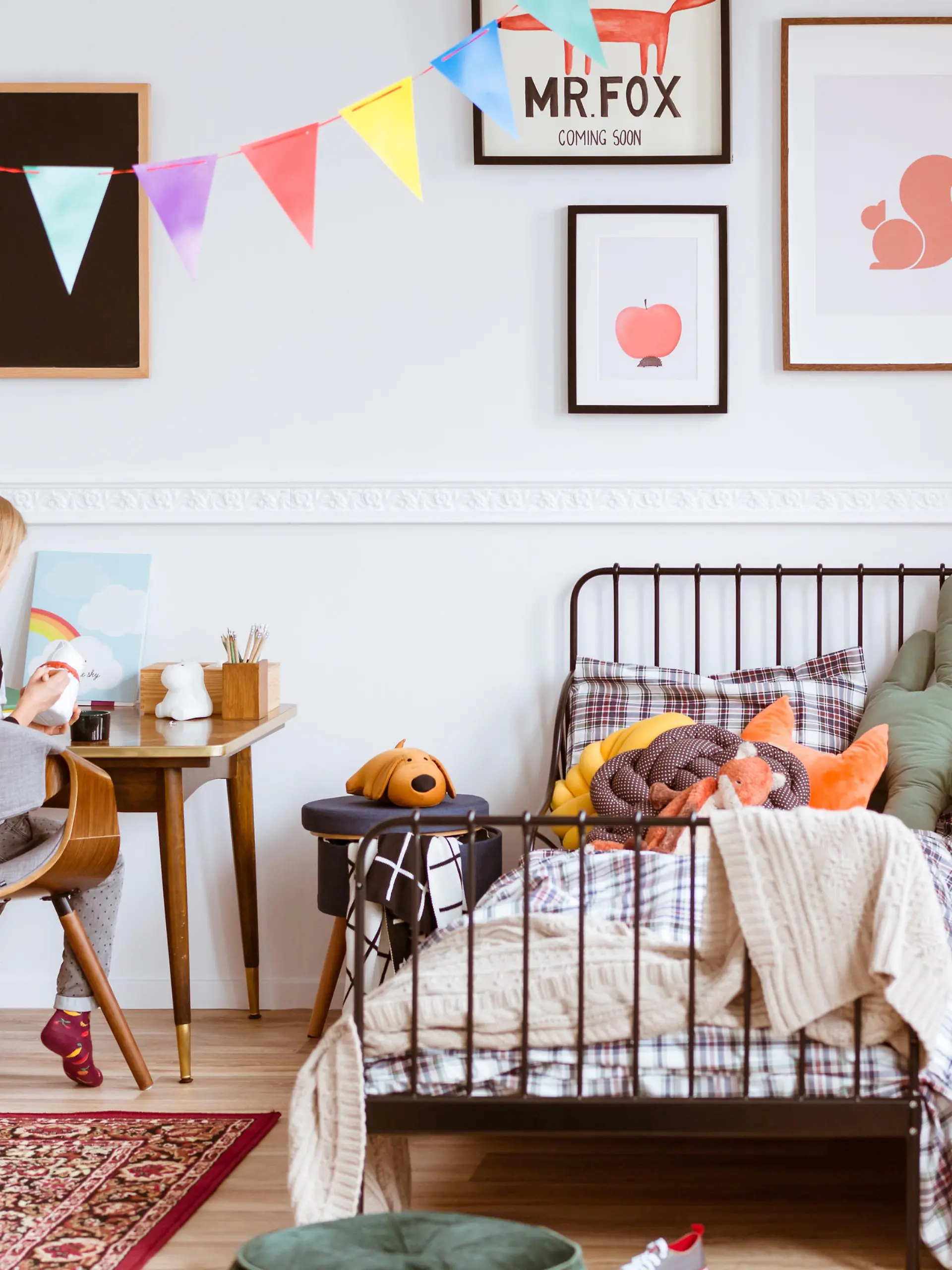 Cute little girl sitting at desk in her stylish vintage bedroom with workspace