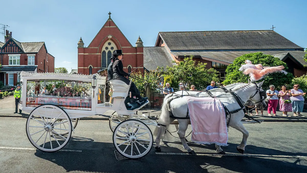 The horse-drawn carriage carrying the coffin of stabbing victim Alice da Silva Aguiar arrives for her funeral at St Patrick’s Church, Southport, England, Sunday Aug. 11, 2024. (Danny Lawson/PA via AP)