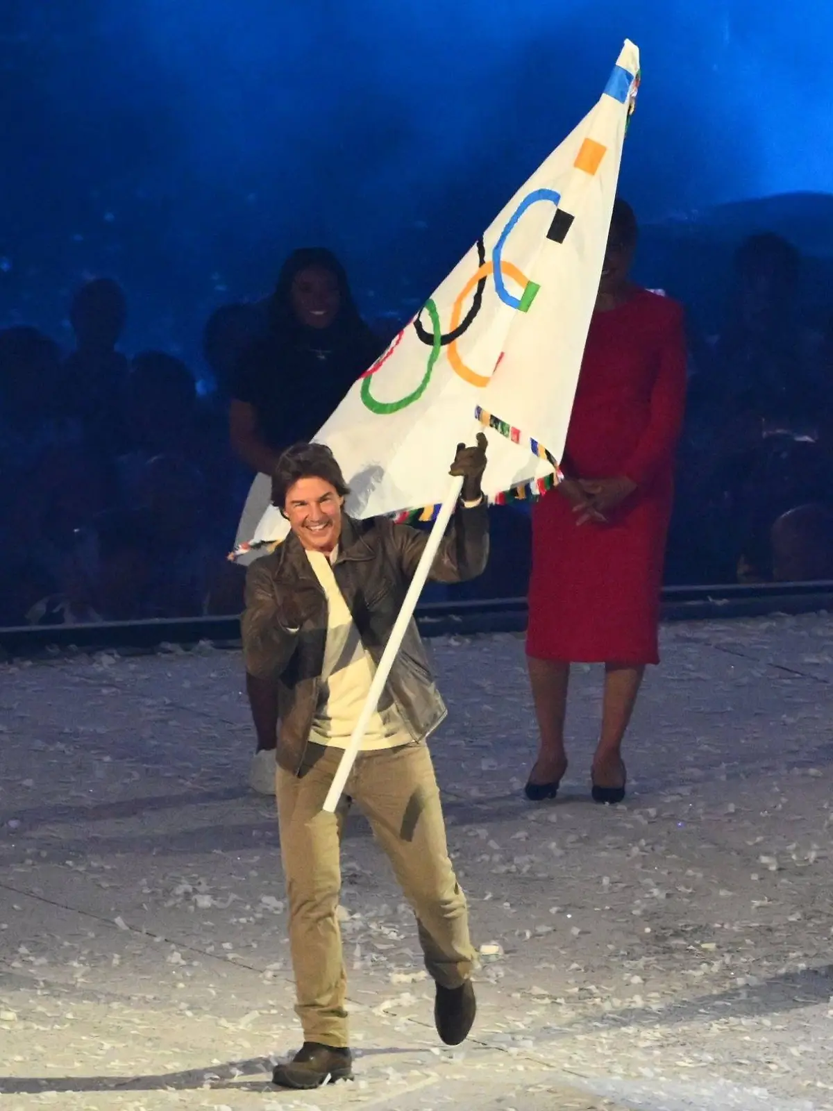 Tom Cruise übernimmt die olympische Flagge.