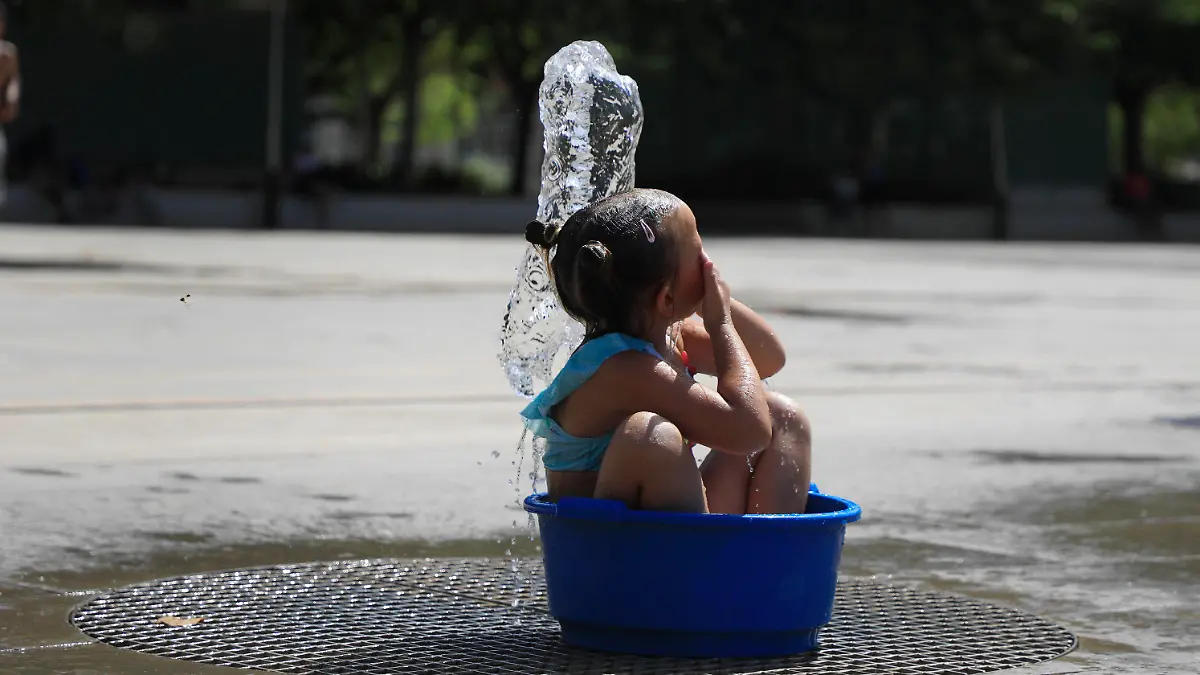 31.07.2024, Spanien, Palma: Ein Mädchen erfrischt sich bei Hitze in einem öffentlichen Brunnen. Foto: Clara Margais/dpa - ACHTUNG: Nur zur redaktionellen Verwendung im Zusammenhang mit der aktuellen Berichterstattung und nur mit vollständiger Nennung des vorstehenden Credits +++ dpa-Bildfunk +++