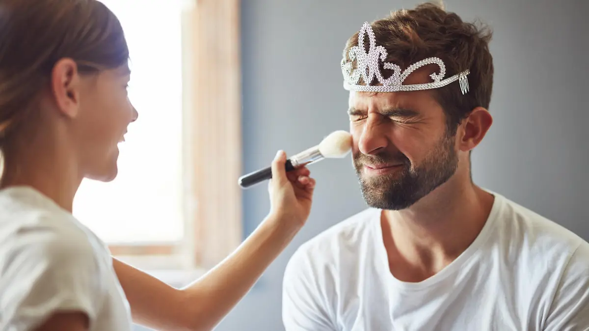 Cropped shot of a little girl putting makeup on her father