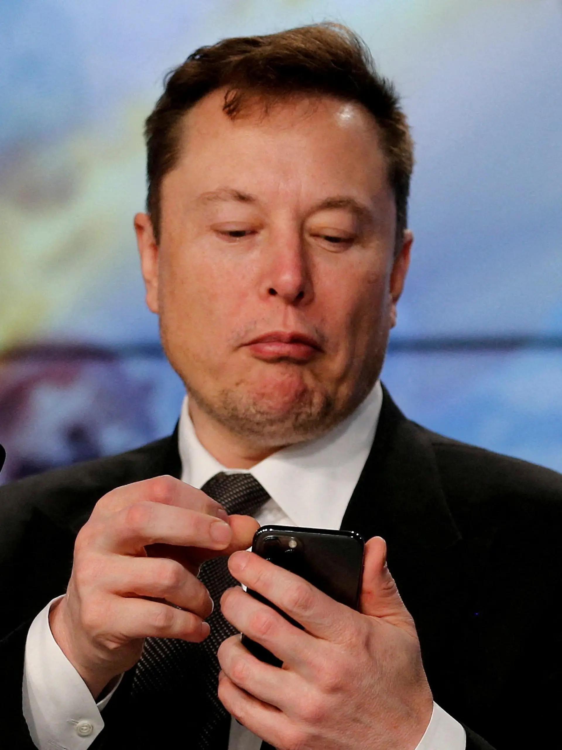FILE PHOTO: Elon Musk looks at his mobile phone in Cape Canaveral, Florida, U.S. January 19, 2020. REUTERS/Joe Skipper/File Photo/File Photo