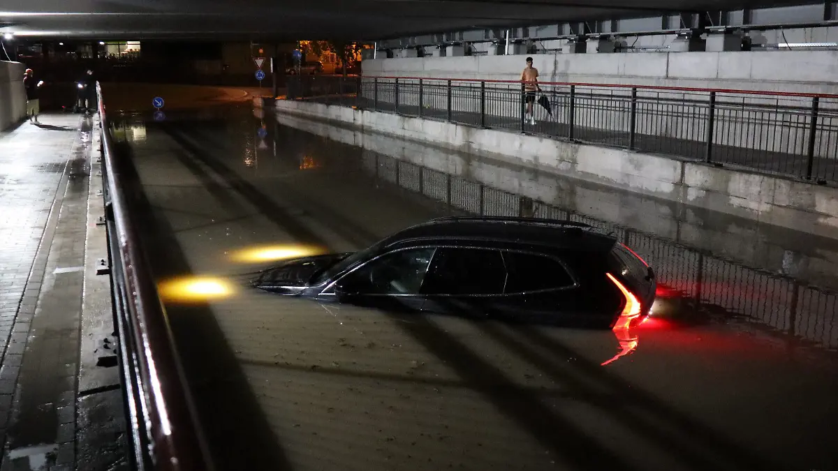 13.08.2024, Baden-Württemberg, Bruchsal: In der sogenannten Siemens-Unterführung steht ein Pkw in einer Unterführung nach einem schweren Gewitter bis zur Motorhaube im Wasser. Foto: René Priebe/dpa +++ dpa-Bildfunk +++