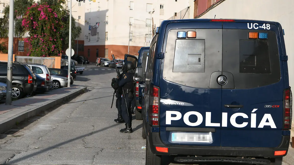 ARCHIV - 10.10.2022, Spanien, Ceuta: Ein Polizeiwagen und Beamte der Nationalen Polizei stehen während eines Polizeieinsatzes im Stadtteil El Principe in Ceuta. Ein Mann wurde in der Nacht bei einer Schießerei getötet. (zu dpa: «Wochenlang an Bett gefesselt - Polizei befreit Frau») Foto: Antonio Sempere/EUROPA PRESS/dpa +++ dpa-Bildfunk +++