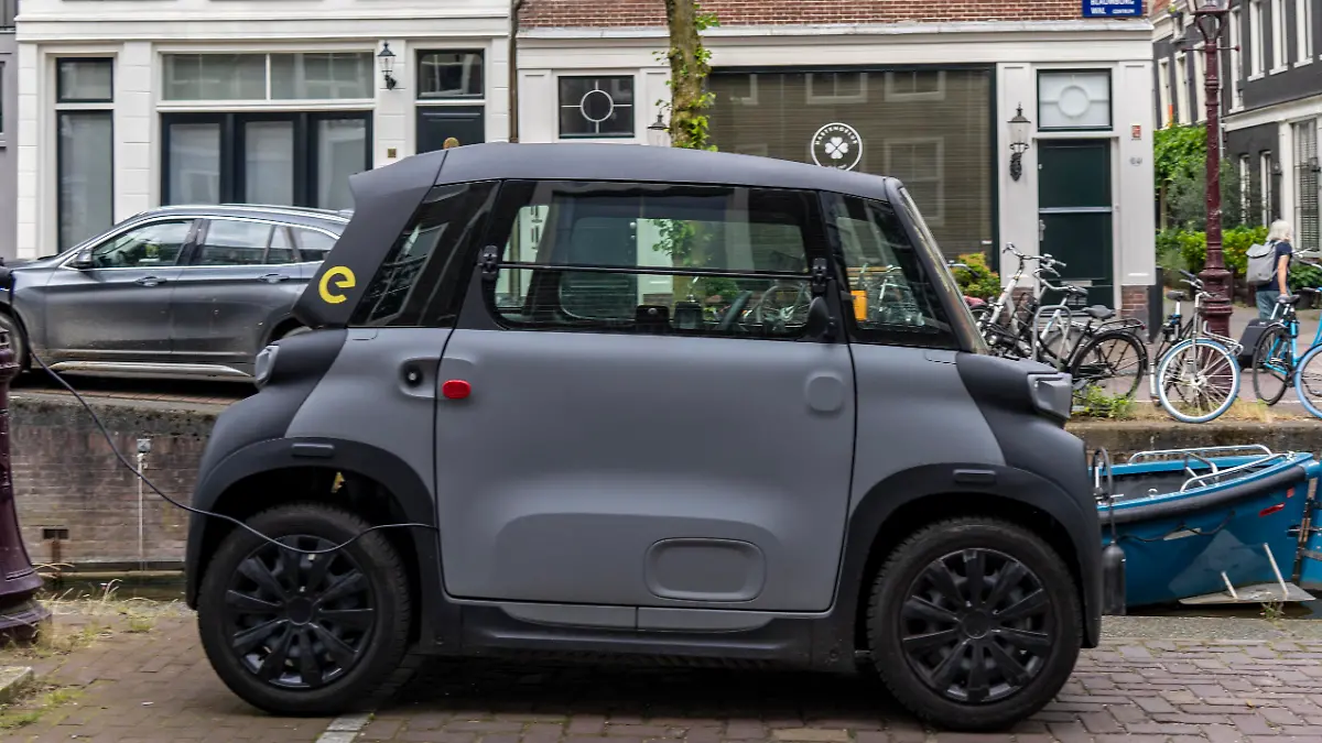 Miniauto in der Altstadt, Blauwburgwal Gracht, Innenstadt von Amsterdam, geparkt, Rocks Electric von Opel, E-Auto, beliebt in der Stadt, weil er wenig Parkraum braucht, darf am 15 Jahren Alter, mit Rollerführerschein, gefahren werden, Niederlande