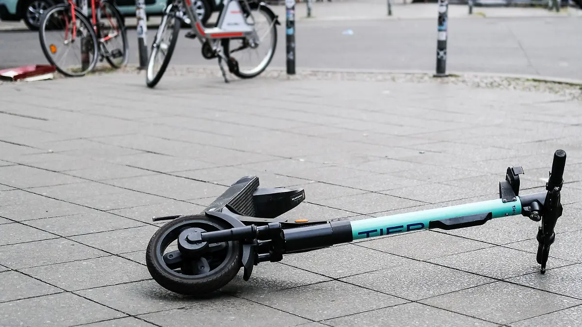 ARCHIV - 24.07.2020, Berlin: Ein E-Scooter liegt umgekippt mitten auf dem Gehweg in der Revaler Straße in Friedrichshain. Nach einem tödlichen Sturz eines Radfahrers über einen E-Roller in Gelsenkirchen ermittelt die Polizei weiter zum Hintergrund des Unfalls. (zu dpa: «Tödlicher Sturz von Radfahrer über E-Roller - Ermittlungen laufen») Foto: Jens Kalaene/dpa-Zentralbild/dpa +++ dpa-Bildfunk +++