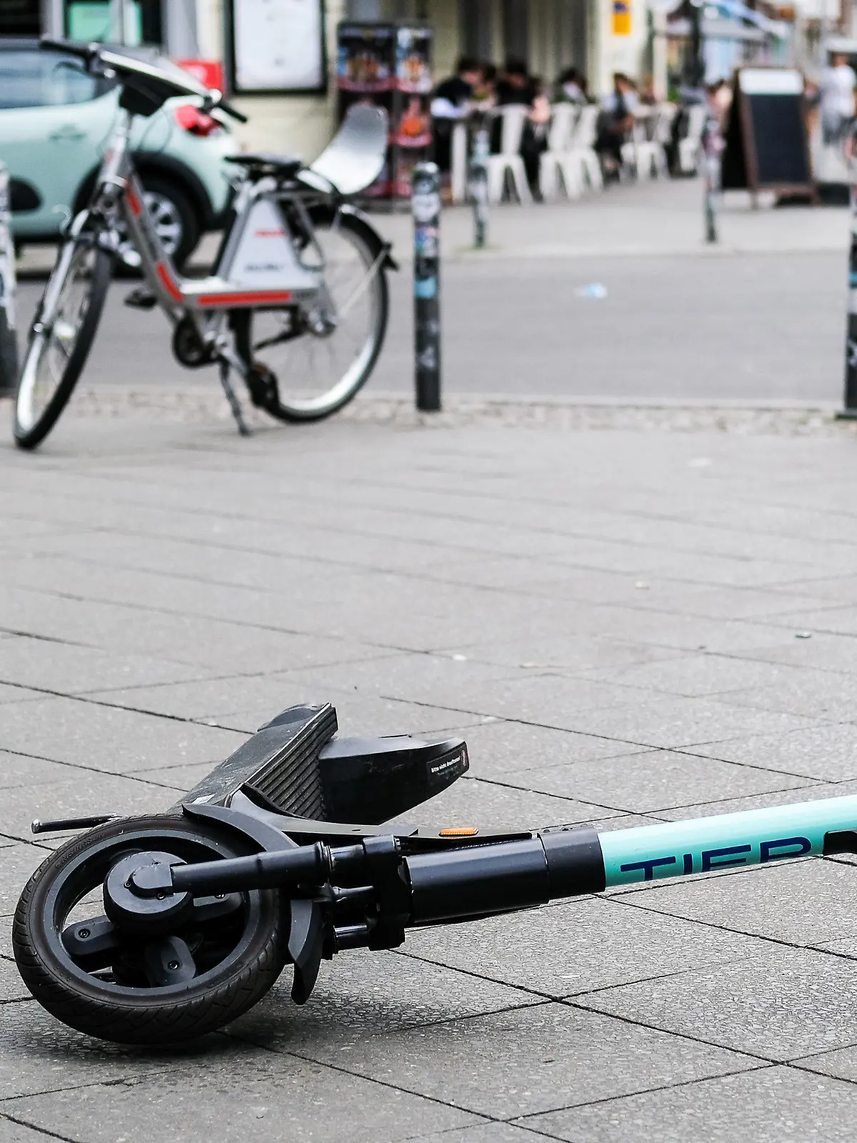 ARCHIV - 24.07.2020, Berlin: Ein E-Scooter liegt umgekippt mitten auf dem Gehweg in der Revaler Straße in Friedrichshain. Nach einem tödlichen Sturz eines Radfahrers über einen E-Roller in Gelsenkirchen ermittelt die Polizei weiter zum Hintergrund des Unfalls. (zu dpa: «Tödlicher Sturz von Radfahrer über E-Roller - Ermittlungen laufen») Foto: Jens Kalaene/dpa-Zentralbild/dpa +++ dpa-Bildfunk +++