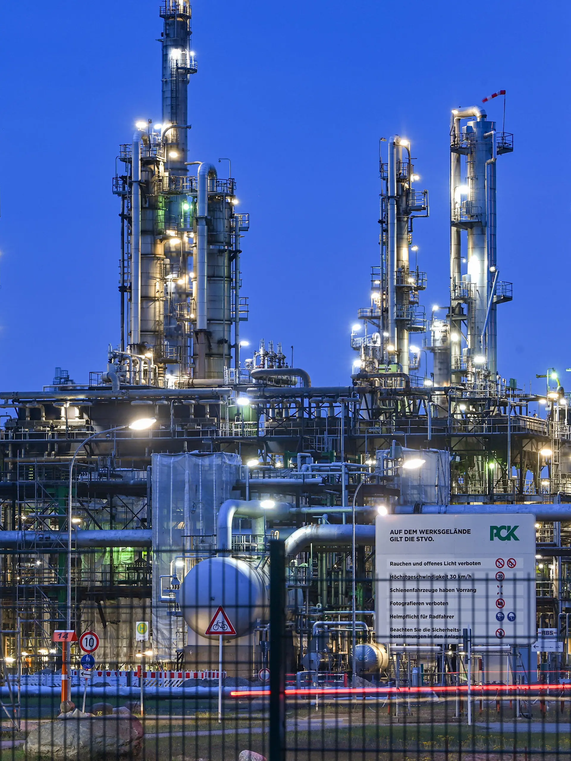 04.05.2022, Brandenburg, Schwedt: Die Anlagen der Erdölraffinerie auf dem Industriegelände der PCK-Raffinerie GmbH sind abends beleuchtet. In der Erdölraffinerie kommt Rohöl aus Russland über die Pipeline «Freundschaft» an. Der russische Energiekonzern Rosneft hatte im vergangenen Jahr einen Großteil der Raffinerie übernommen. Rosneft ist der größte russische Ölproduzent. Die Anlage in der Uckermark verarbeitet nach eigenen Angaben jährlich 12 Millionen Tonnen Rohöl und gehört damit zu den größten Verarbeitungsstandorten in Deutschland. Foto: Patrick Pleul/dpa +++ dpa-Bildfunk +++